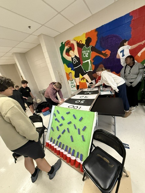 Students playingplinko/shuffleboard carnival game