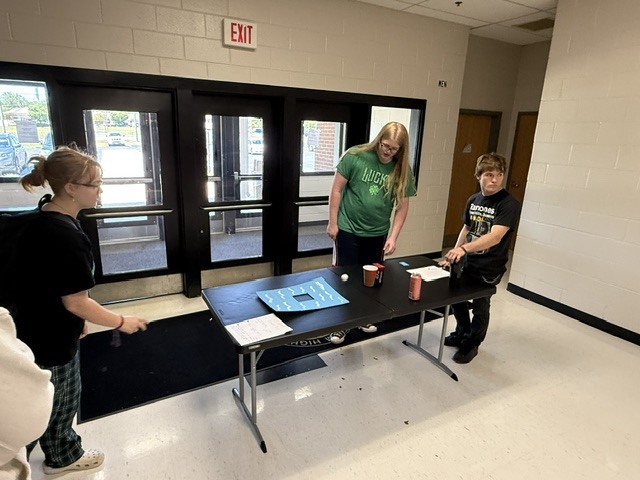 Students playing ball toss carnival game