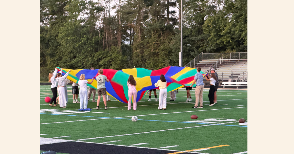 Students playing with large parachute
