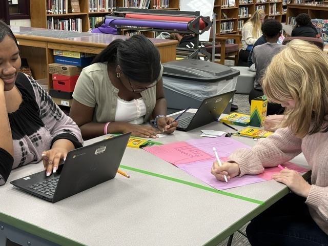 Students collaborating on a board game for Algebra
