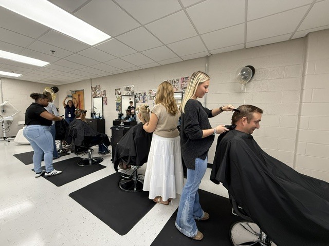 Students cutting hair of clients