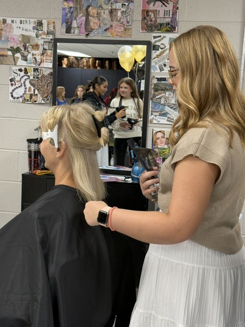 Student preparing to cut hair of AP