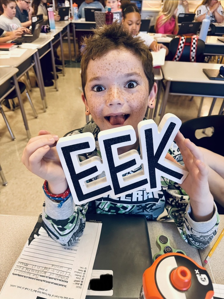 Student holding EEK sign.