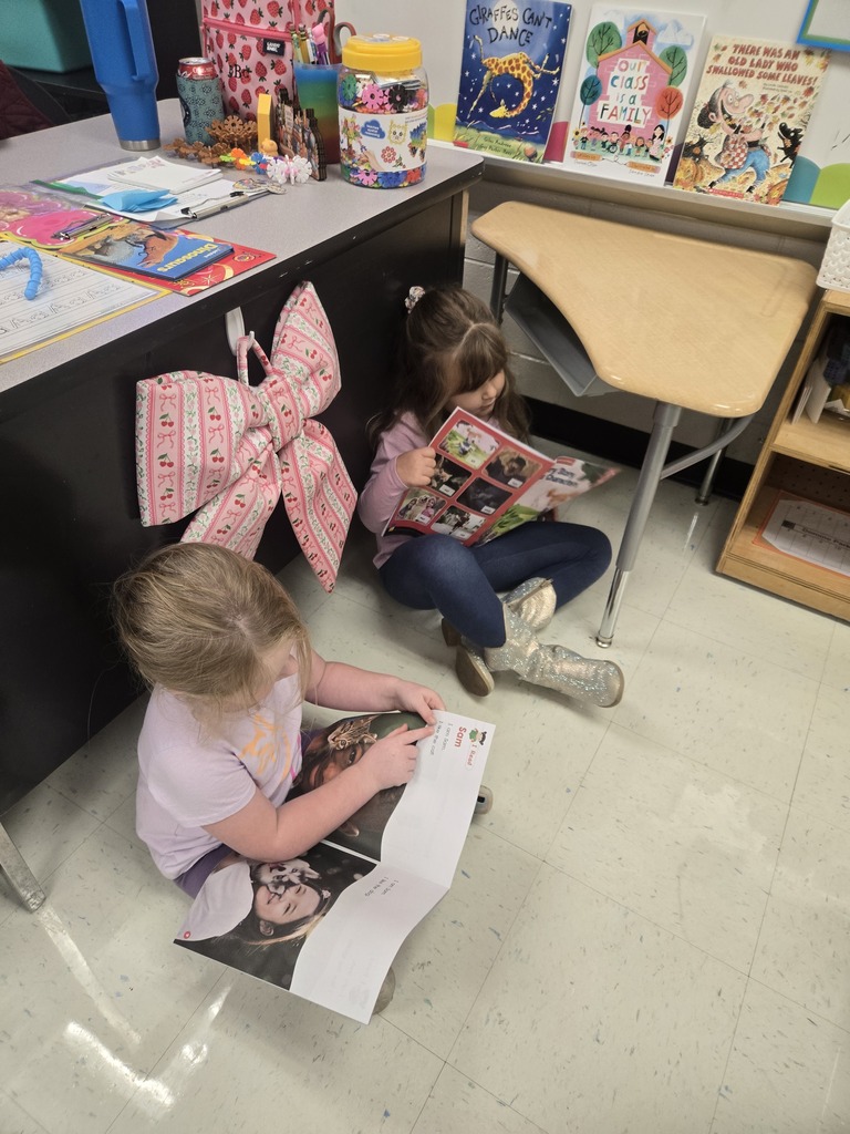 Two students reading to each other.