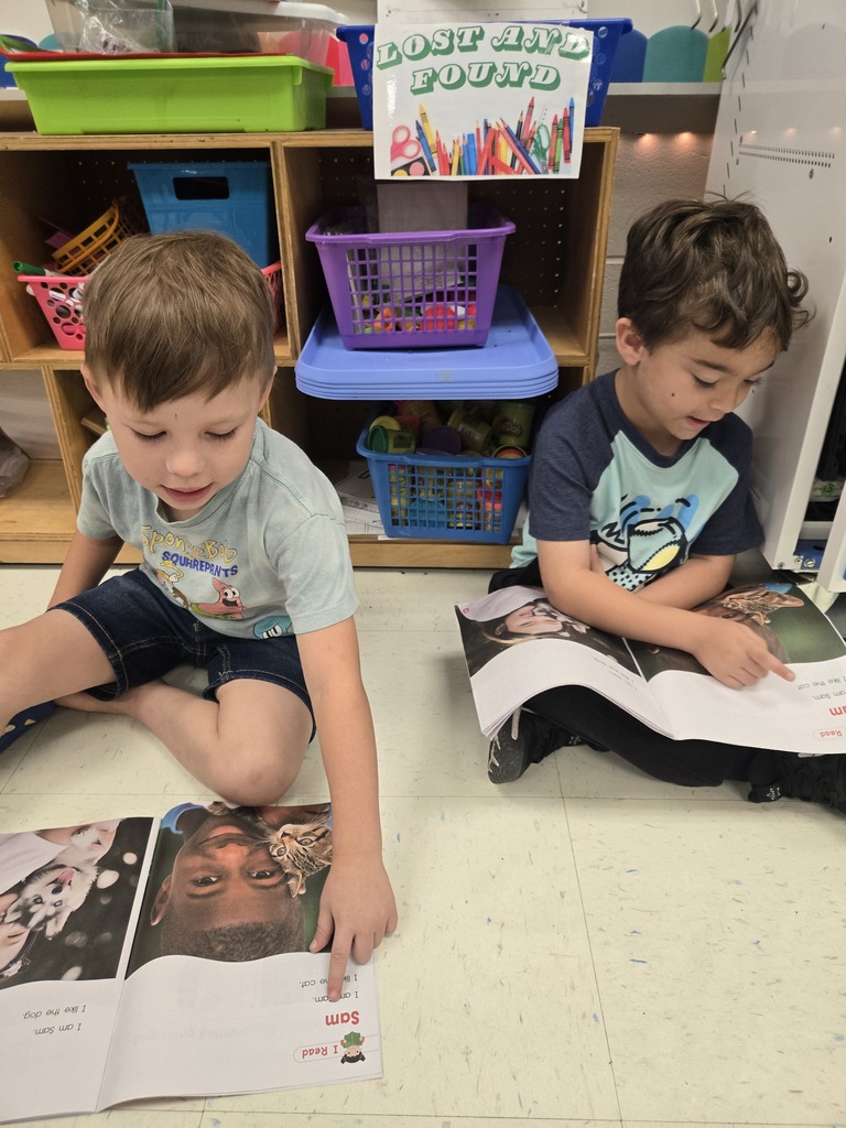 Two students reading to each other.