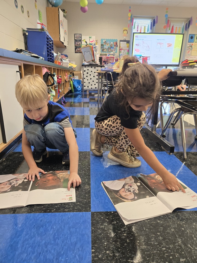 Two students reading to each other.