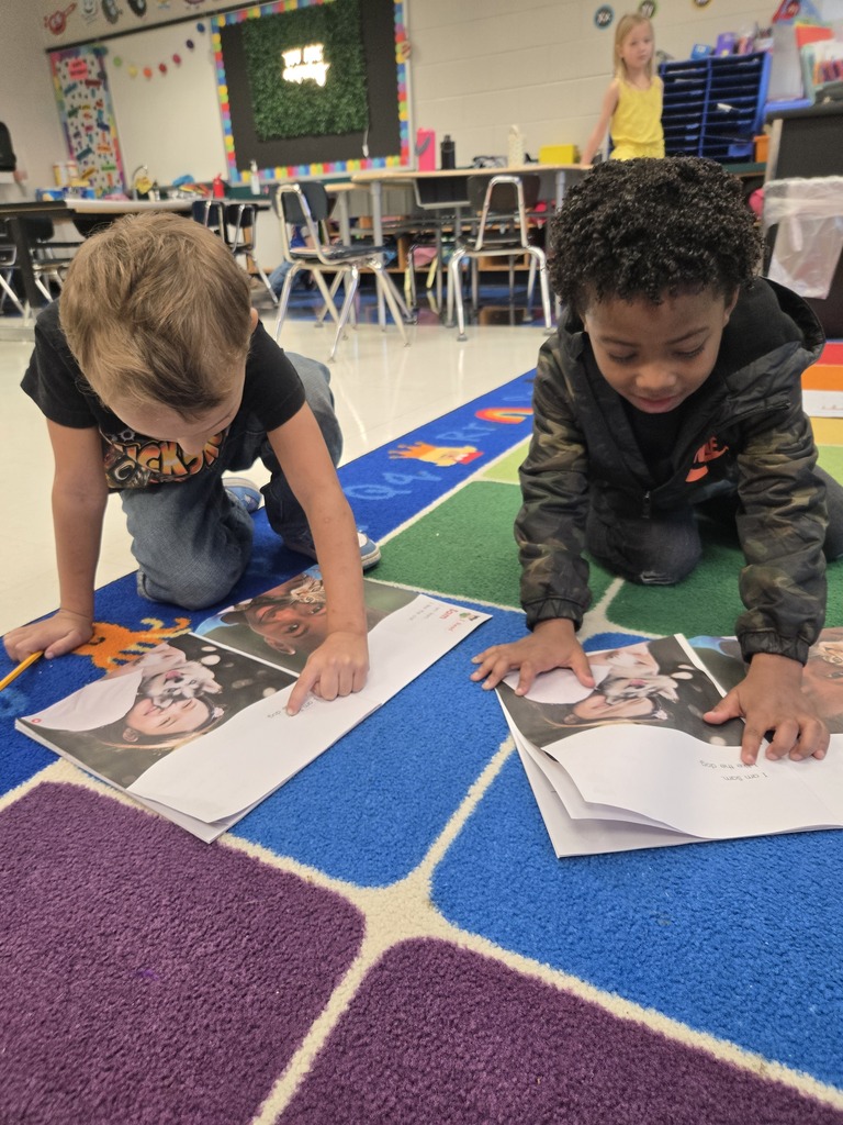 Two students reading to each other.