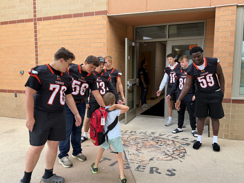 Football players greeting KPS Students.