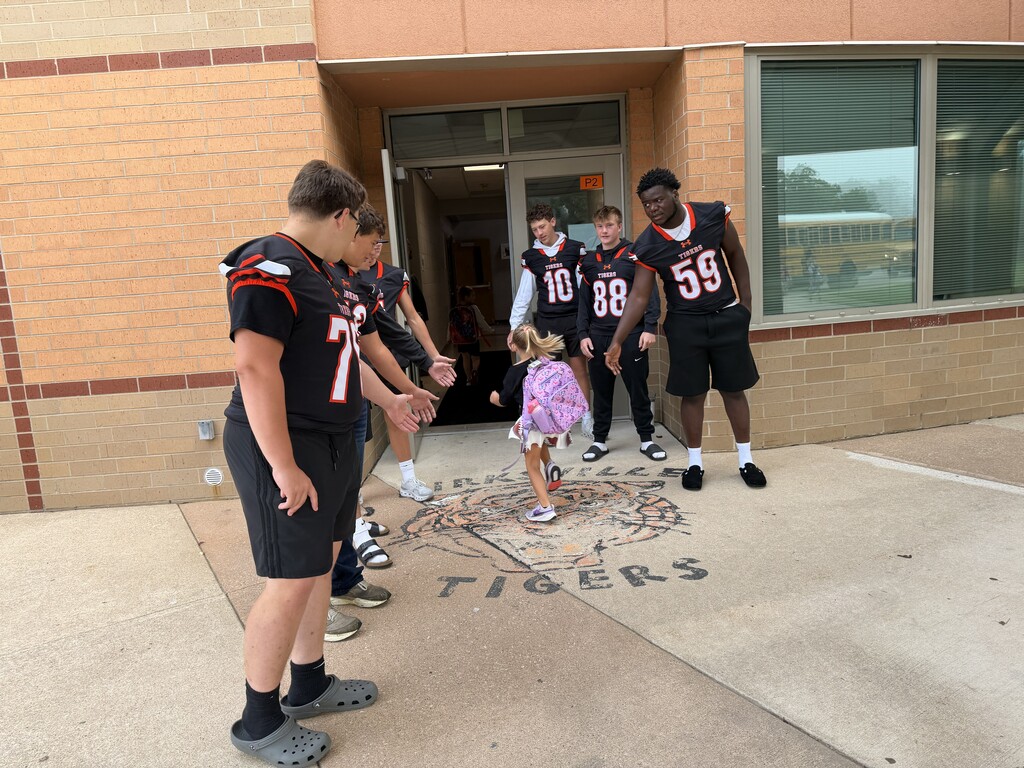 Football players greeting KPS Students.