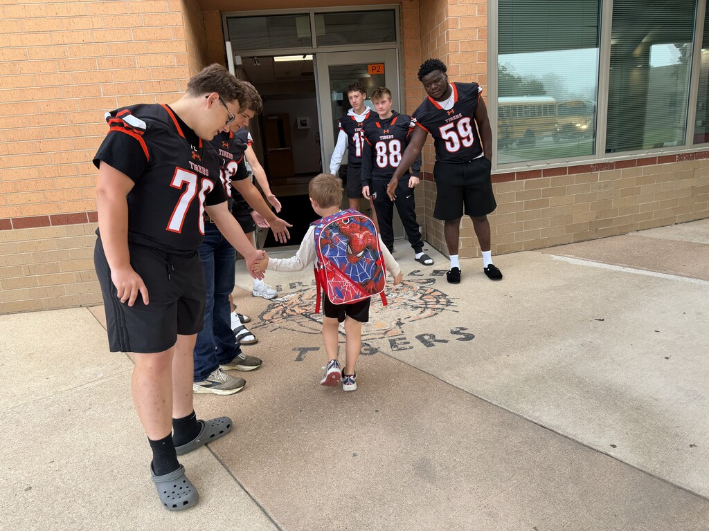 Football players greeting KPS Students.