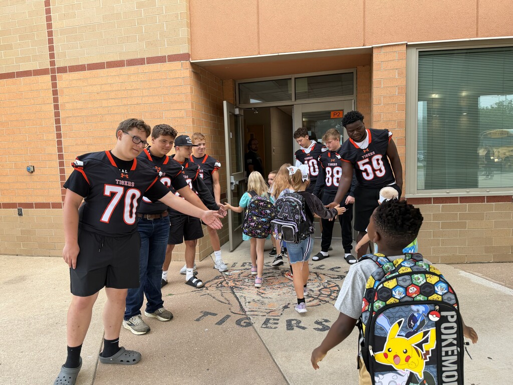 Football players greeting KPS Students.