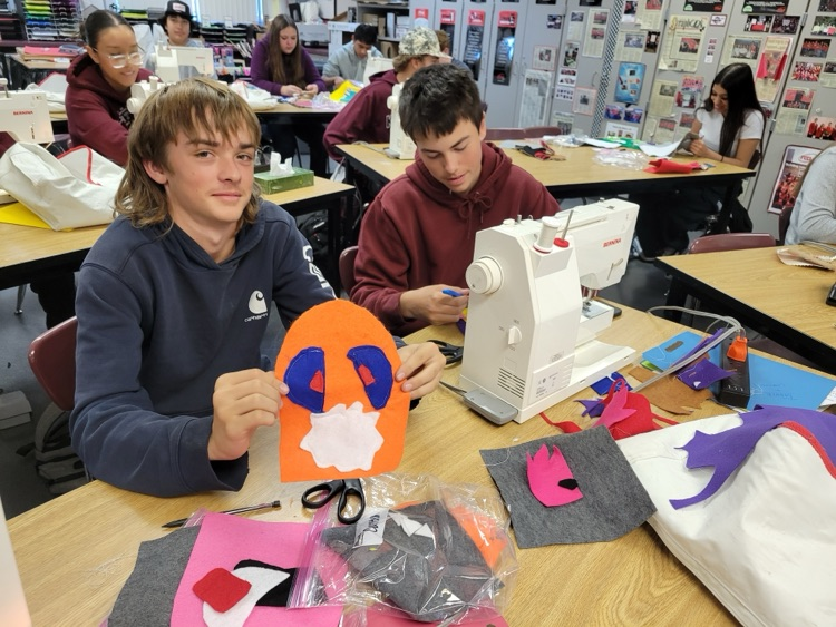 high school students working on sewing project