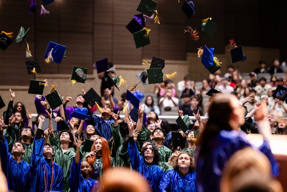 winter graduates throw their caps