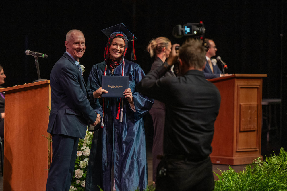 graduate smiles and receives diploma