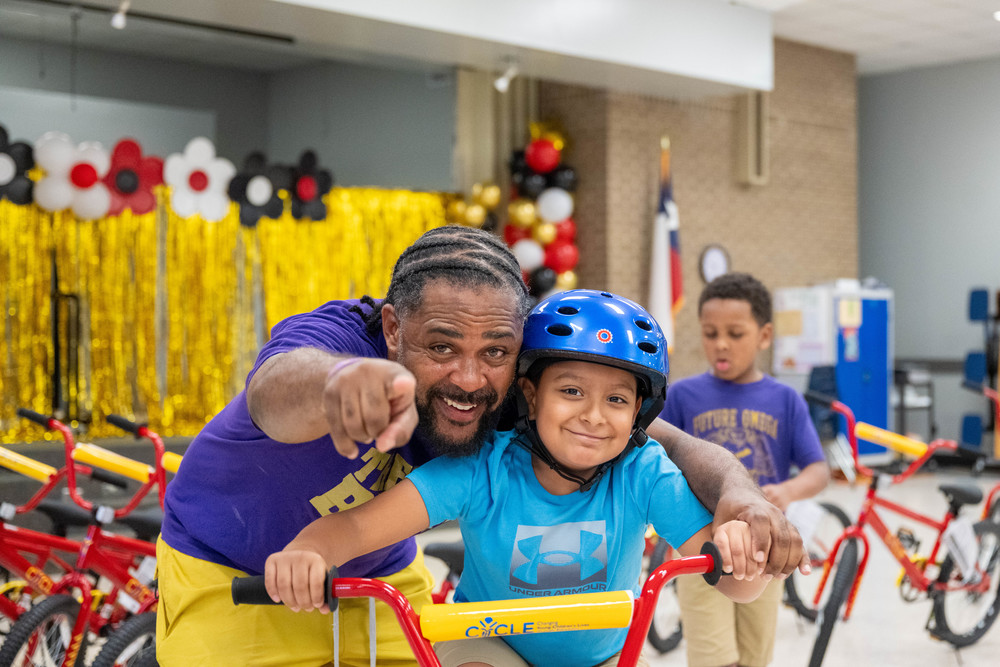 man and student on bike smiling at camera