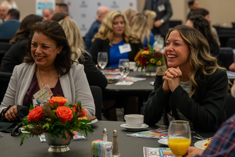 2 ladies smile at a breakfast event