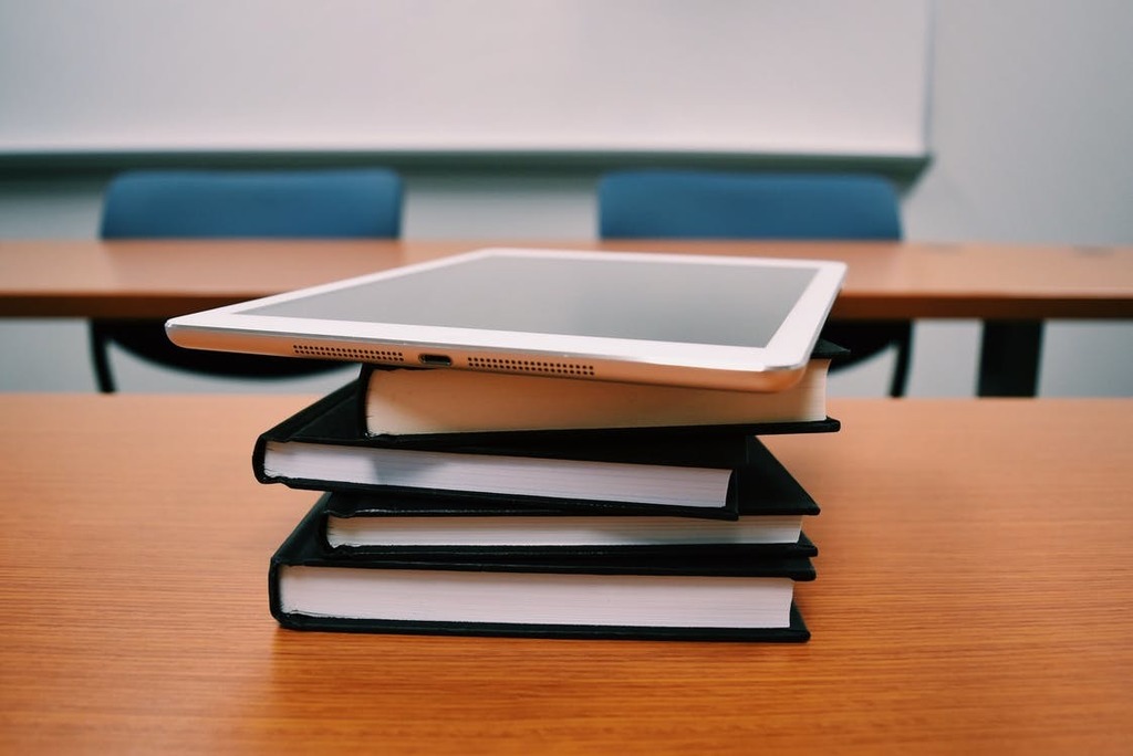 tablet on a stack of books in a classroom