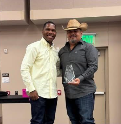 Chief Runnels and Officer Pulido holding an award. 