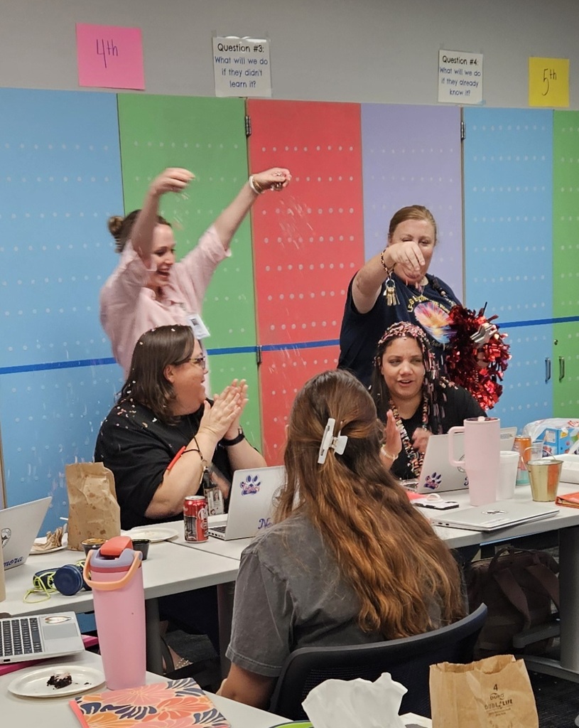 teachers at a table with confetti falling around them