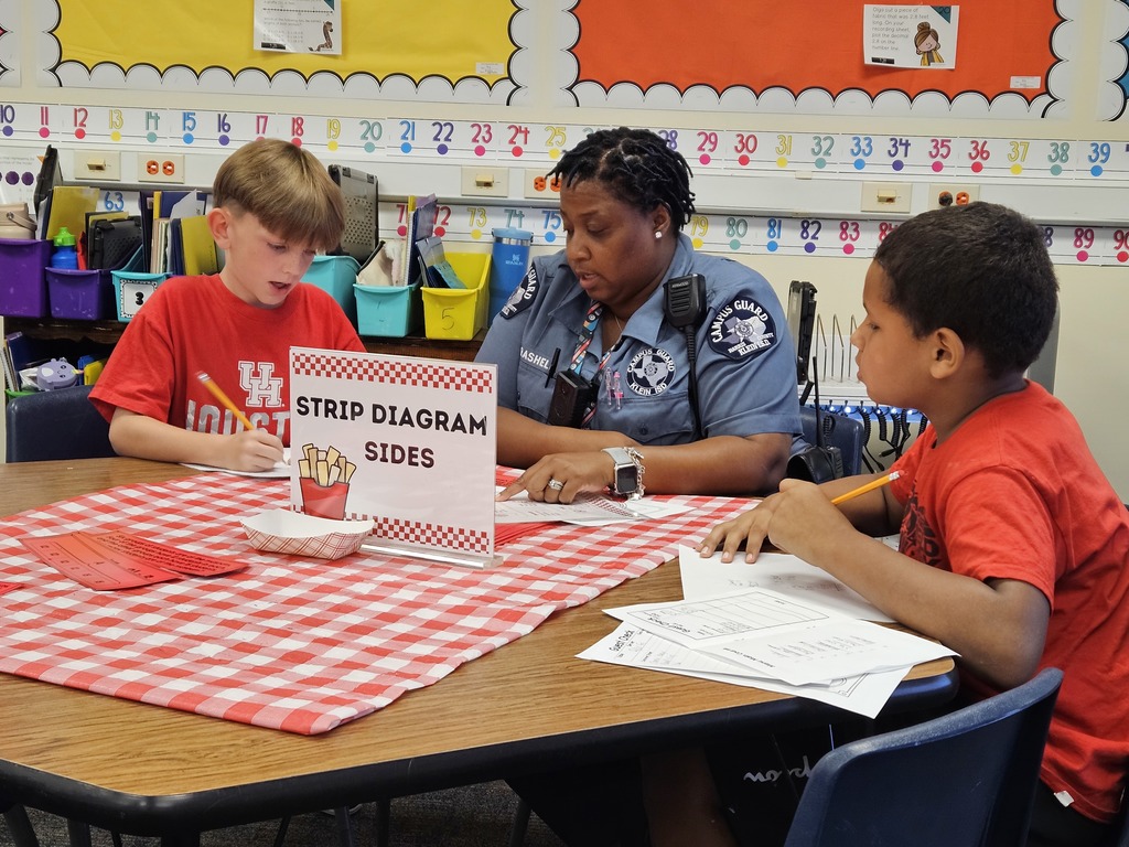two students are working at a table with the campus guard