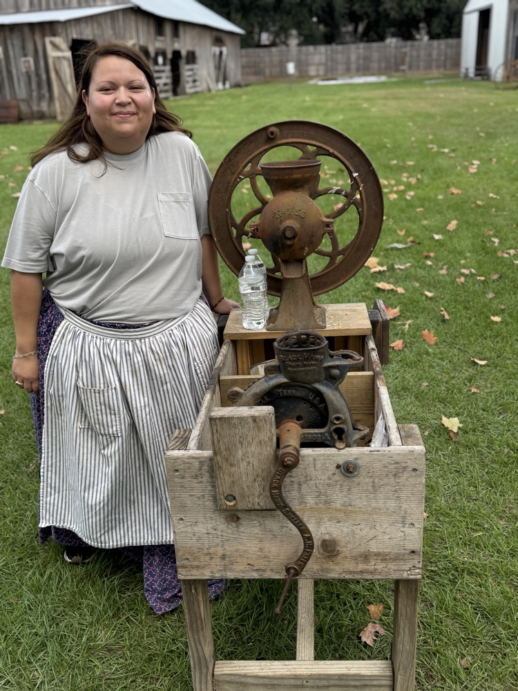 Educator as a docent teaching student how the corn mill was used. 