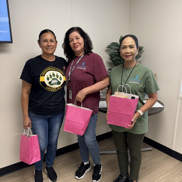3 school custodians with pink gift bags