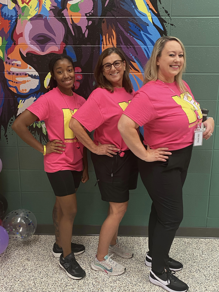 3 women coaches in pink shirts.
