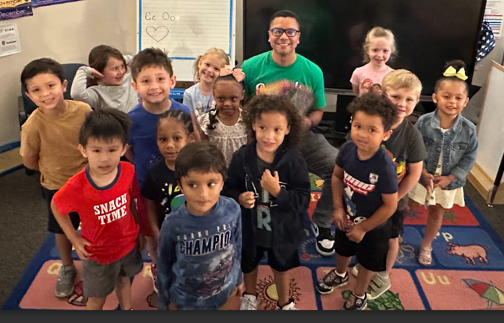 Mr. Menendez posing with a clasroom of students