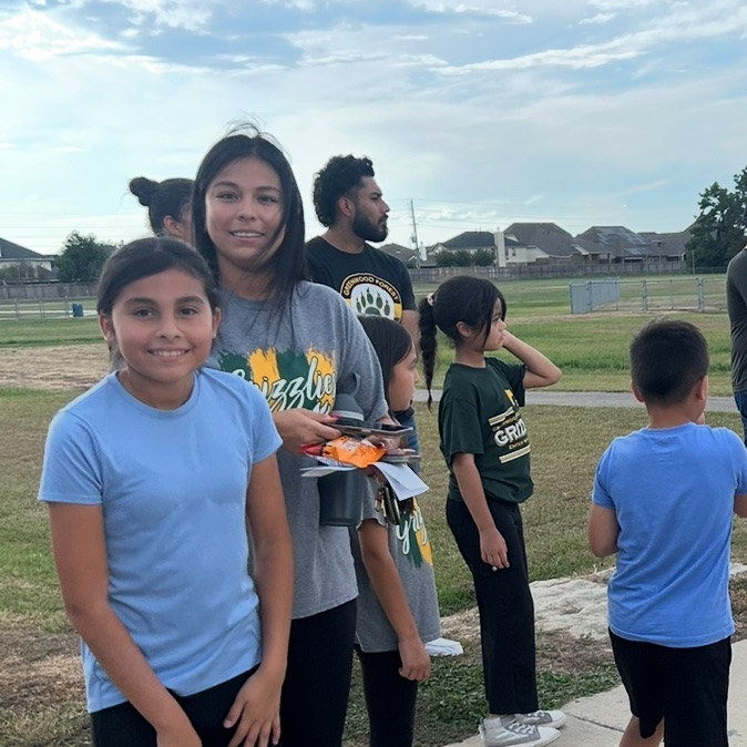 Family in blue and gray shirt on track field