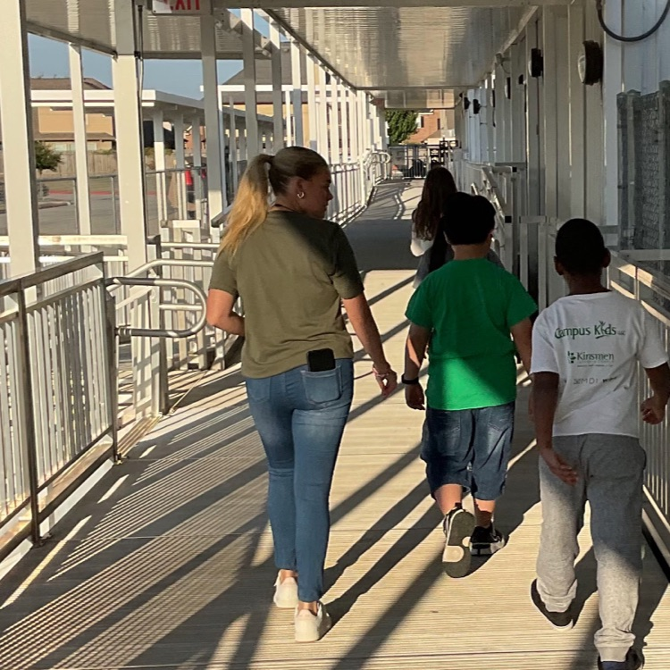 resident walking students to lunch room using outside hallway area of Flex School