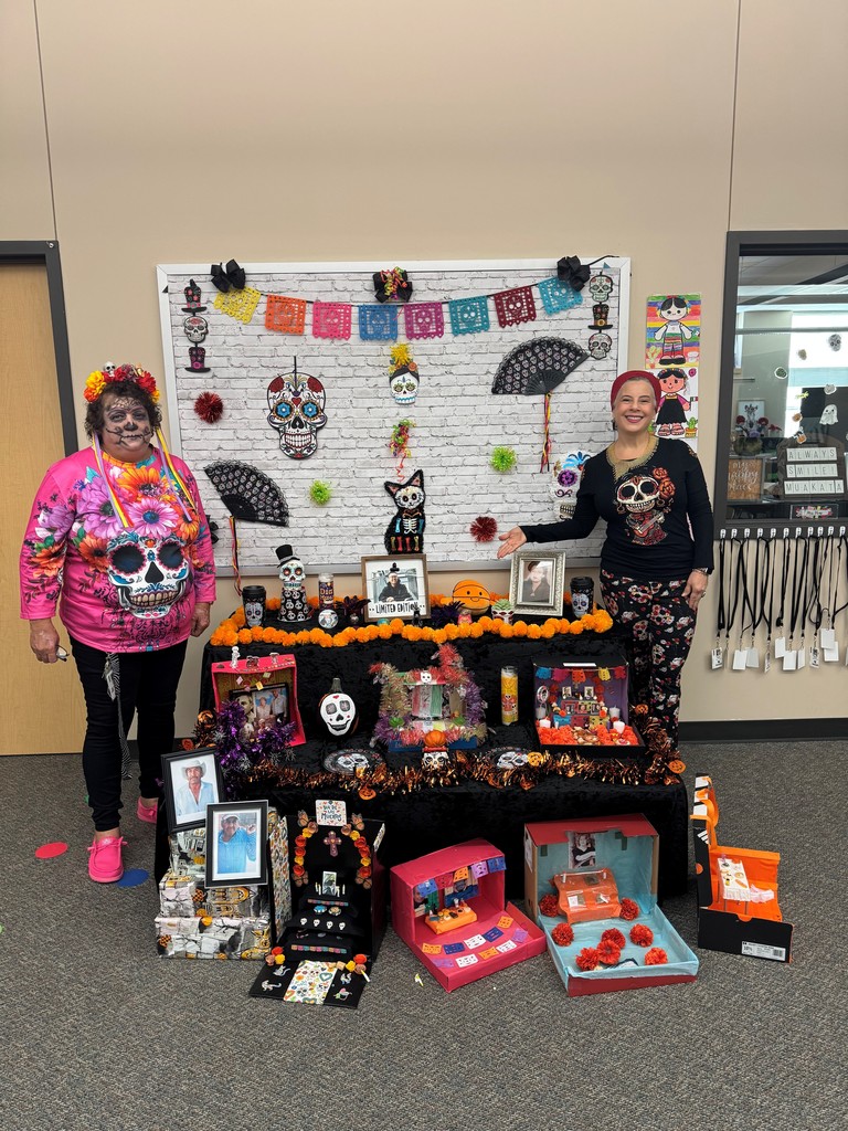 Teachers pose with the 2nd grade dual language dia de los muertos altar