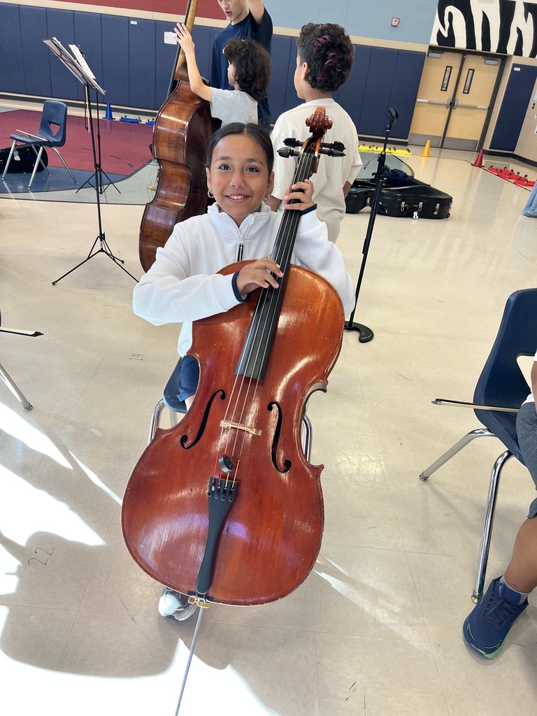 High school student showing a 5th grader how to hold an instrument