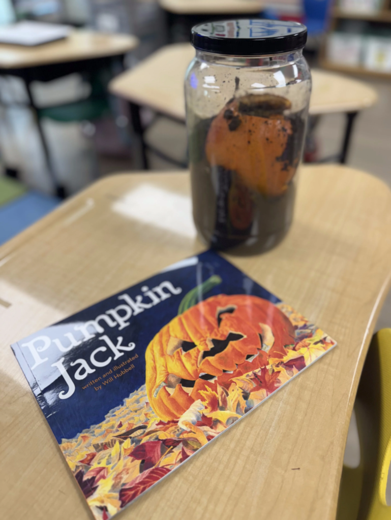 Punkin in glass container with a book titled, "Pumpkin Jack"....