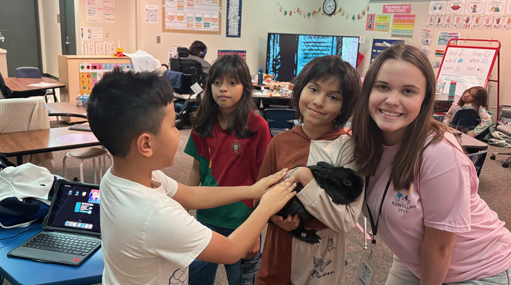 Klein Collins student with some 5th graders in a classroom