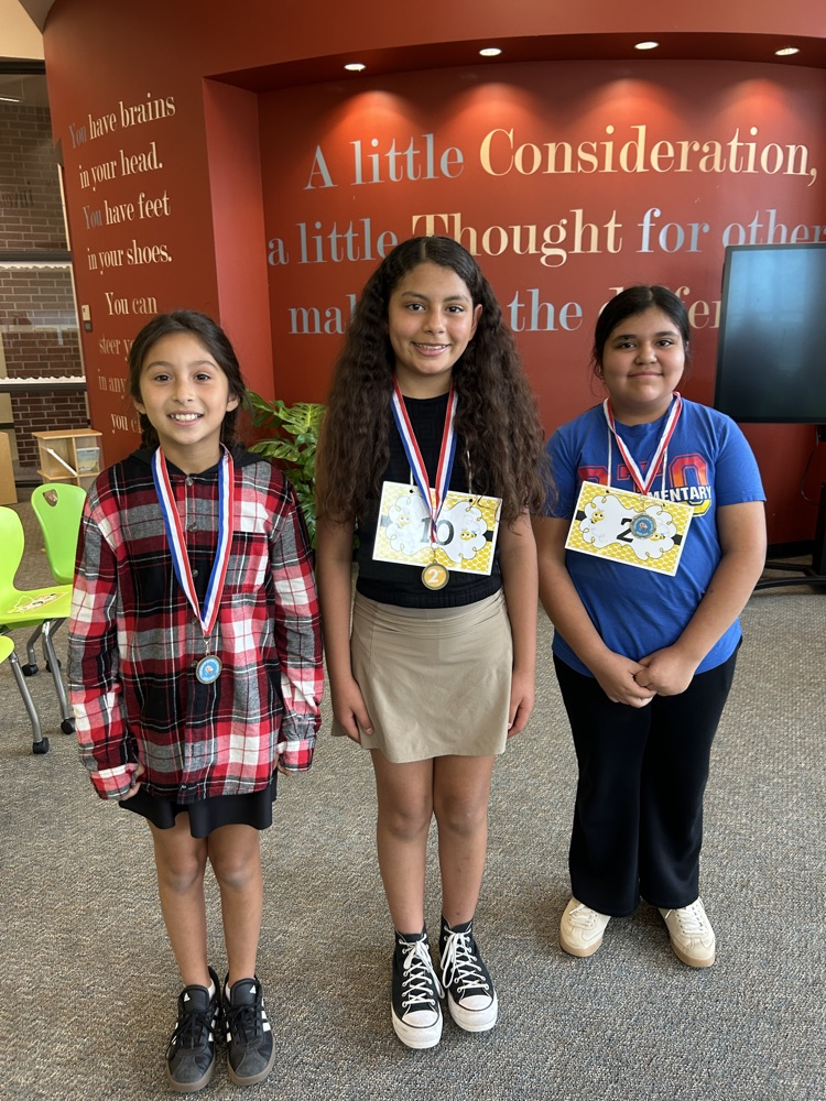 1st, 2nd, and 3rd place winners stand together wearing their medals