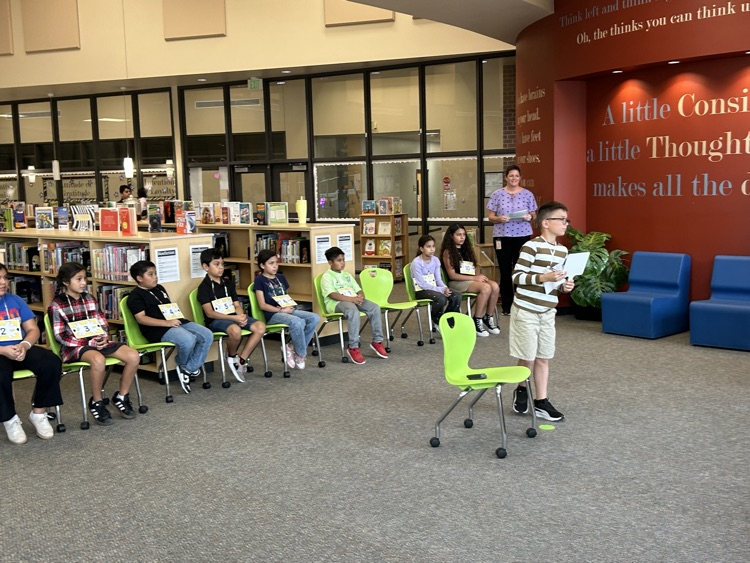 One contestant is standing in front of the other contestants spelling his word