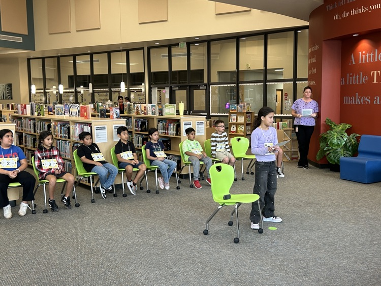 One contestant is standing in front of other contestants spelling her word