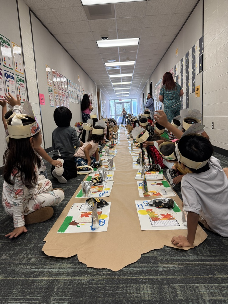 children sitting on the floor looking at teacher.
