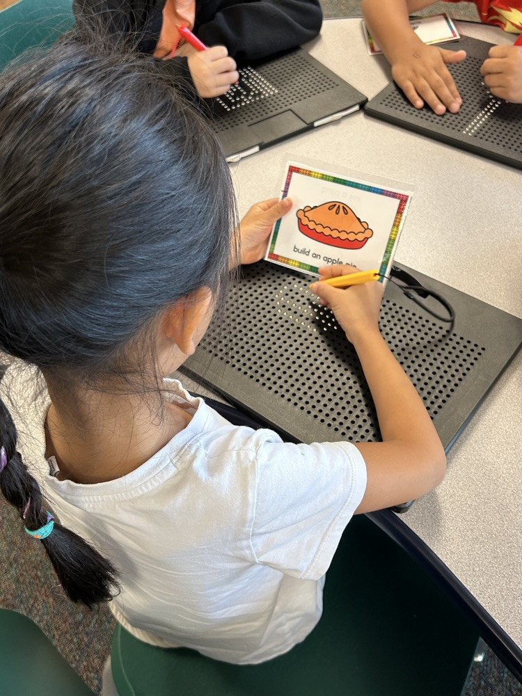 a student using magnetic drawing boards to make a pie