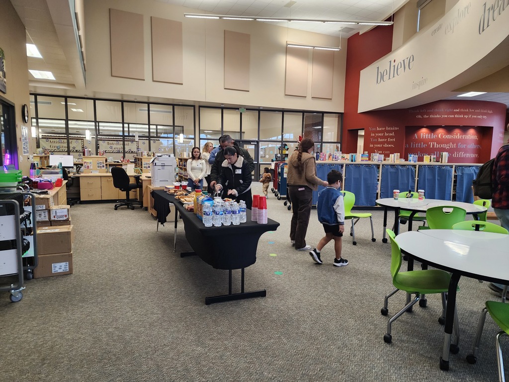 Families in line for a buffet breakfast in the school library