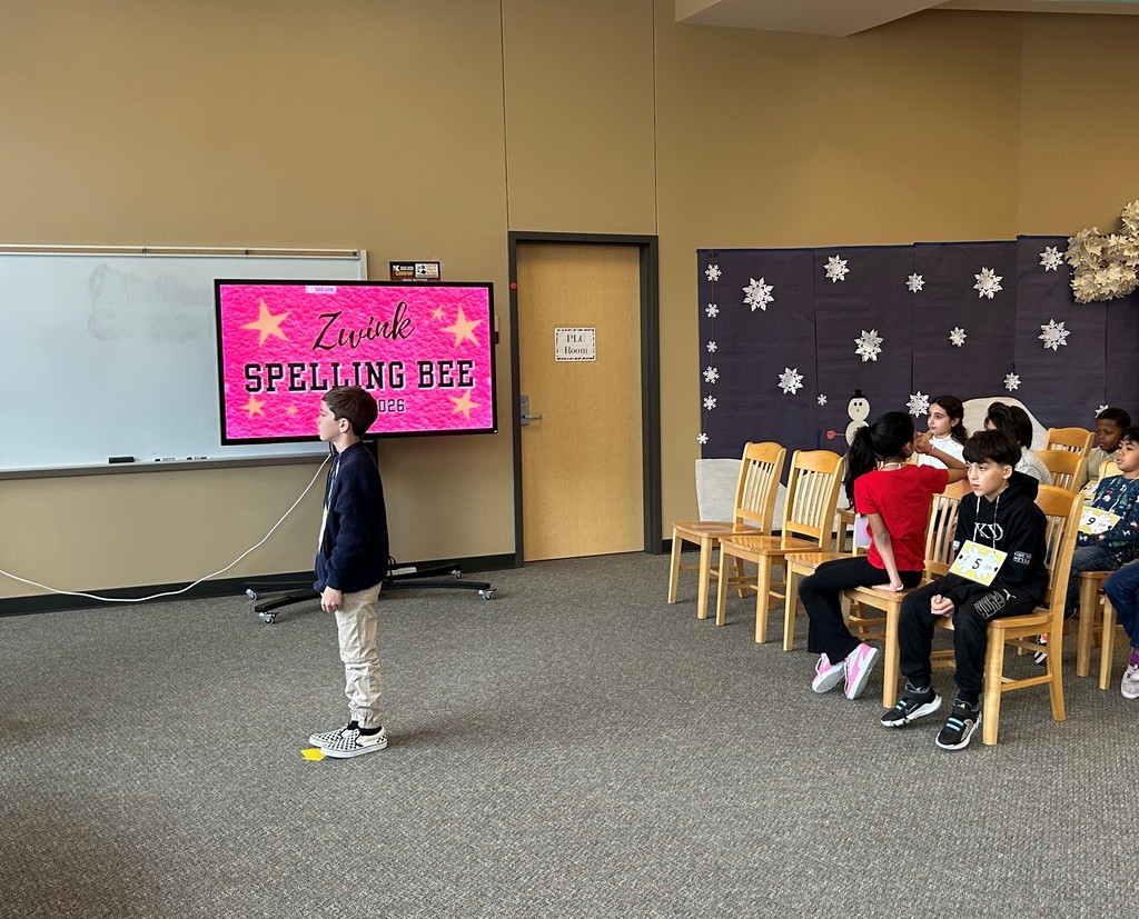 Student waiting for word in spelling bee. Other contestants sit in the background.