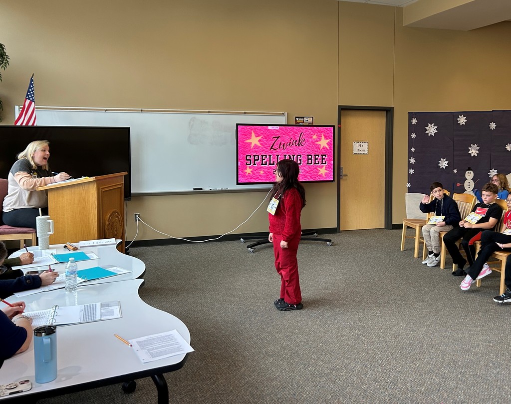 Student waiting for word in spelling bee. Proctor stands in background behind podium.