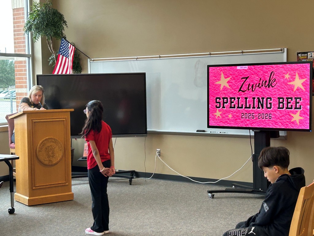 Student waiting for word in spelling bee. Proctor stands in background behind podium.
