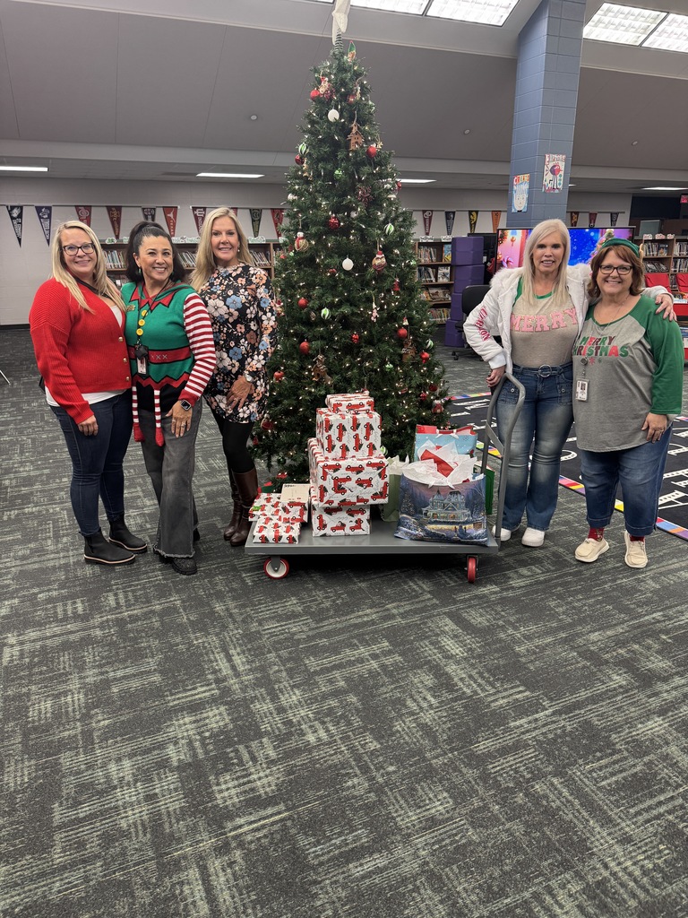Group of women with gifts by tree.