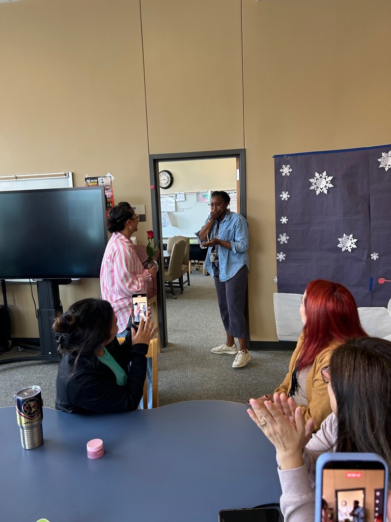 Mrs. Solomonson accepting her reward from Mrs. Galicia while colleagues applaud.