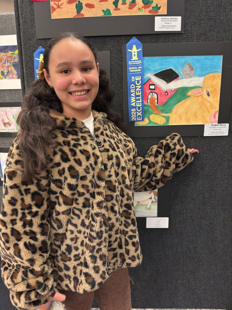 Student posing in front of student art work