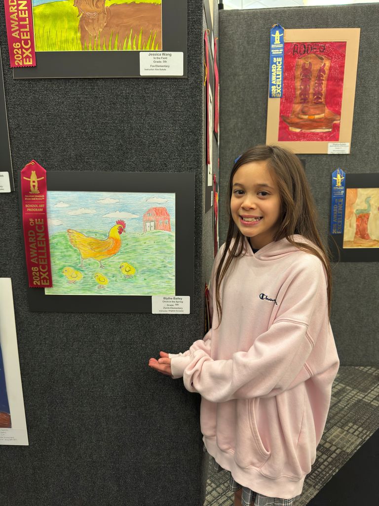 Student and teacher posing in front of student art work