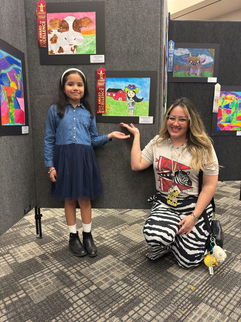 Student and teacher posing in front of student art work