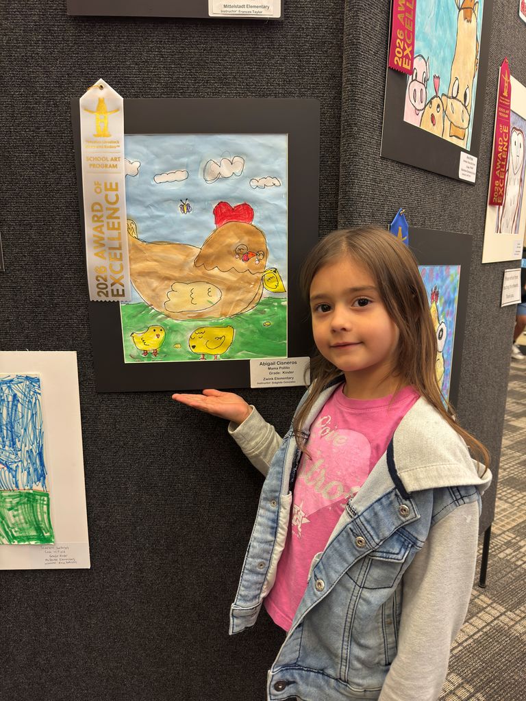 Student and teacher posing in front of student art work