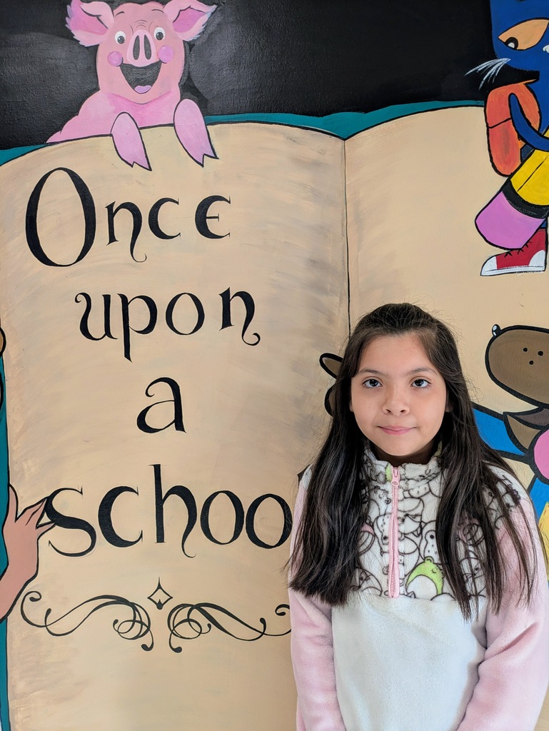 student standing in front of a mural that says once upon a school